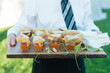 Mini grilled cheese sandwiches with tomato soup shooters at an event