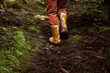 Close up of child's muddy yellow boots in forest