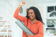 © Daniel Ernst - Excited black woman with yoga mat ready for class at gym