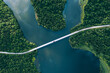 Aerial view of bridge asphalt road with cars and blue water lake and green woods