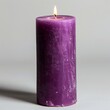 Purple candle on a white background with a lighted candle