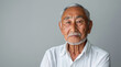Serene elderly asian man gazes calmly at the camera, his face expressing wisdom and the beauty of advanced age, neutral background , copy space