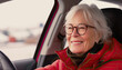 Gray-haired elderly woman with glasses driving. Active old age. Transportation and technology. Horizontal photograph. 
