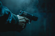 male hand holding gun over dark background