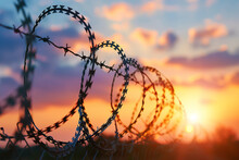 Barbed Wire Fence Against The Background Of Sunset Sky. Conceptual Photo On Security, Museum And Border Control Theme. Closeup
