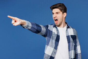 Wall Mural - Young sad Caucasian man he wear shirt white t-shirt casual clothes point index finger aside scream shout command do it isolated on plain blue cyan color background studio portrait. Lifestyle concept.