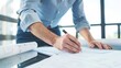 Architect reviewing detailed construction drawings, close-up, focused on blueprint details 