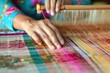 © Vikarest - Asian woman weaving fabric on a loom. Close-up of working hands