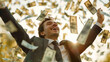 © ALL YOU NEED studio - handsome young businessman is happy, throwing money in the air, wearing suit . The background of falling dollars in motion blur