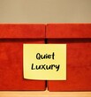 Boxes with stick note written QUIET LUXURY , lifestyle trend with more exclusive, intimate and personalized experience less visible branding - more simplicity and mindfulness