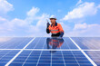 Engineer einspects solar panels, angle view blue sky backgrounds,