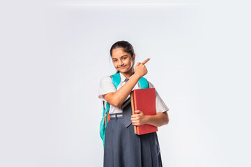 Asian Indian teenage schoolgirl in school uniform with different expressions standing against white