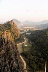 Wall Mural - dirt road leading through the valley at sunset in Vang Vieng, the adventure capital of Laos