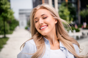 Poster - Photo of adorable young blonde hair smiling woman wearing blue shirt satisfaction spring vacation walking outside her residential complex