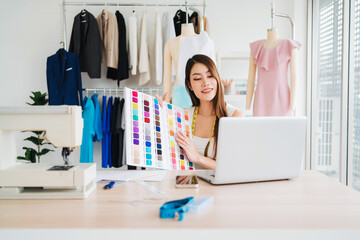 Beautiful Asian female fashion designers or dressmakers show the sample fabrics swatch to the client in the online meeting. Fashion designer working in the studio. Small business concept.