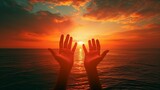 Fototapeta Koty - Silhouetted hands reaching towards the sunset over the ocean.
