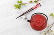 Table with teapot and chopsticks adorned with cherry blossom branch