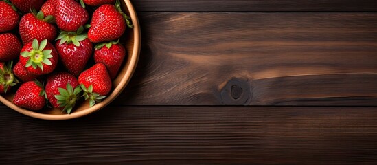 Poster - A copy space image of ripe red strawberries arranged on a wooden plate set against a wooden backdrop