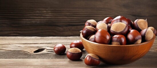 A copy space image showcasing a bowl of fresh chestnuts placed on a rustic old wooden backdrop