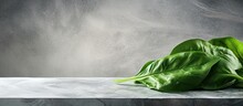 A Copy Space Image Of A Fresh Organic Arrow Shaped Spinach Leaf Positioned On A Marble Textured Table Background