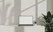 Illustrate a minimalist studio setup highlighting a laptop mockup on a white screen