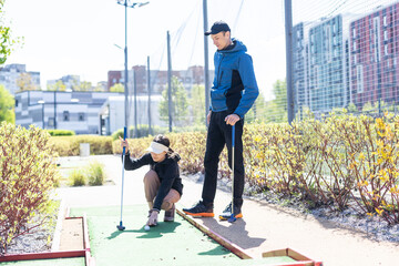 Wall Mural - young handsome father teaching his little daughter how to play golf