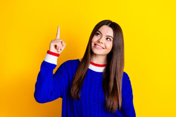 Poster - Photo portrait of pretty teen girl point look up empty space wear trendy knitwear blue outfit isolated on yellow color background