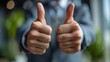 Close-up of a professional offering a two thumbs up sign, expressing approval, achievement, or consensus in a corporate environment