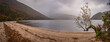 Epic panoramic view with lake, beach, trees, valley and rocky steep mountain. Bad Depressing weather. Lough Dan lake in Wicklow Mountains, Ireland