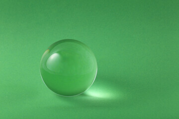 Sticker - Transparent glass ball on light green background. Space for text