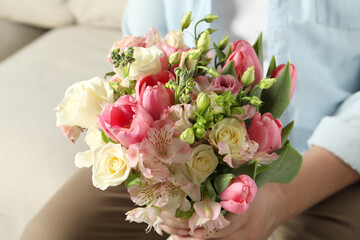 Man holding bouquet of beautiful flowers indoors, closeup