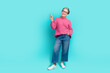 Full length photo of good mood woman wear pink sweater denim pants directing look at sale empty space isolated on teal color background