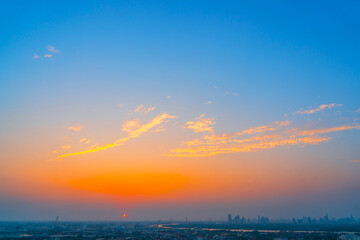 Wall Mural - Yellow blue orange gradient with clouds over the city