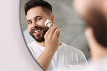 Poster - Handsome young man shaving beard near mirror in bathroom