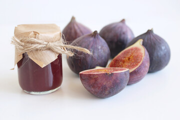 Sticker - Fresh ripened purple figs. Creative composition a decorative banner of whole and sliced exotic fruit and fig jam isolated on white table background.Food photography.