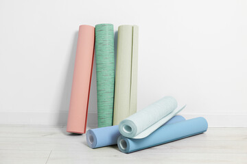 Sticker - Colorful wallpaper rolls on light wooden floor in room