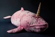 A cute pink stuffed whale with a horn, perfect for children's toys or fantasy themed designs