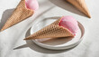 Delicious pink ice-cream in waffle cone on light background. Sweet food. Tasty treat.