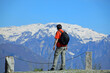 Hiker with black hair and backpack looking at snow-capped mountains