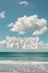 White t-shirts hanging on a clothesline with a clear blue sky and fluffy clouds, symbolizing freshness