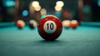 © Armin - A vividly colored close-up of a red and white number 10 billiard ball on the felt surface of a pool table with other balls in backdrop