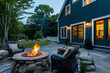 Dark turquoise Cape Cod style vacation home with a stone patio area featuring a fire pit, ideal for chilly evenings.