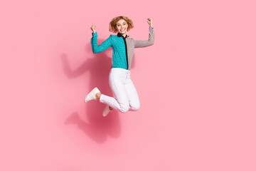 Sticker - Full size photo of pretty young girl jump raise fists winning wear trendy striped cyan outfit isolated on pink color background