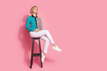 Poster - Full size photo of pretty young girl model sit chair look empty space wear trendy striped cyan outfit isolated on pink color background