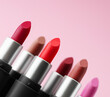 Various lipstick set in a row on a pink