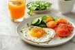 Nutritious breakfast  fried egg with veggies, orange juice on white table, soft focus background