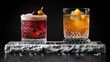   A marble slab holds two glasses brimming with drinks and one with oranges and cherries nearby