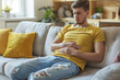 Man Sitting on Couch Holding Stomach