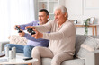 © Pixel-Shot - Mature brothers playing video game at home