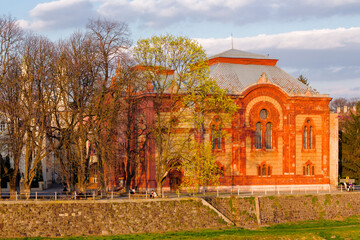 Wall Mural - Uzhhorod, Ukraine - mar 22, 2014: Philharmonic Orchestra Concert Hall on the bank of the river Uzh in spring. former building of synagogue is a popular tourist attraction in evening light